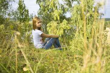 Naklejka na ściany i meble young girl sitting in the grass