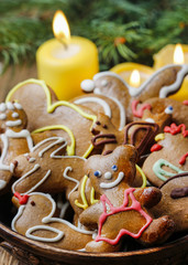 Bowl of gingerbread cookies and green fir branch.