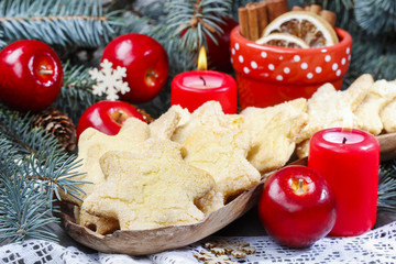 Christmas cookies in star shape, red apples and green fir
