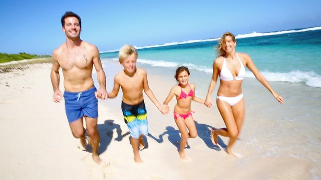 Family running on a paradisiacal beach