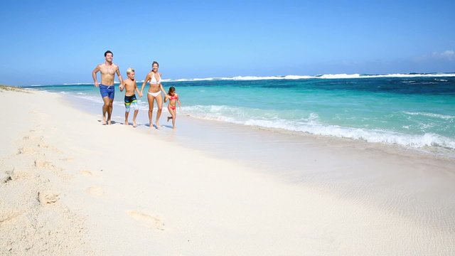Family running on a paradisiacal beach