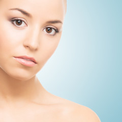 Fototapeta premium Spa portrait of a young and healthy girl on a blue background