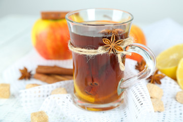 Hot beverage in glass cup with fruits and spices,