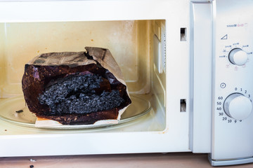 Burnt paper bag with melted and burnt popcorn