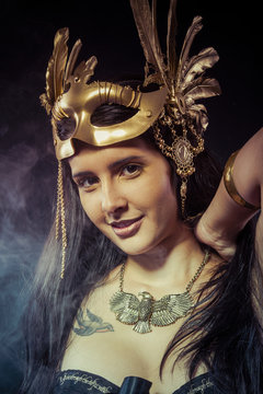 Posing warrior woman with gold mask, long hair brunette. Long ha
