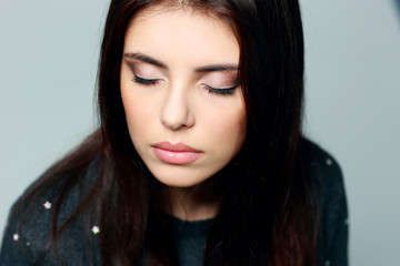 Obraz premium Closeup portrait of a young pensive woman with closed eyes