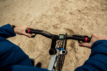 a man with a bicycle on the sand