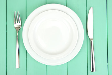Plate and cutlery on wooden table close-up