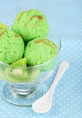 Delicious ice cream on glass vase on blue tablecloth