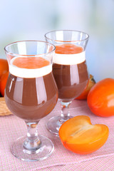 Dessert of chocolate and persimmon on table on light background