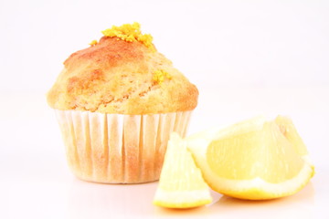 Lemon muffin and a piece of lemon on a white background