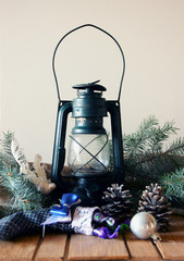Kerosene lantern, pine cones and fir-tree branch