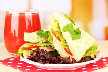 Fresh and tasty sandwiches on plate on table on light