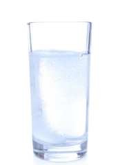 Glass with efervescent tablet in water with bubbles isolated