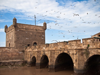 Fortress tower with a bridge on the sky background