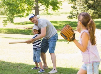 Family playing baseball in the park - Powered by Adobe