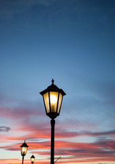 Fototapeta na wymiar old lamps shining in sunset sky