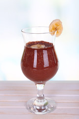 Cocktail with banana and chocolate on table on light background