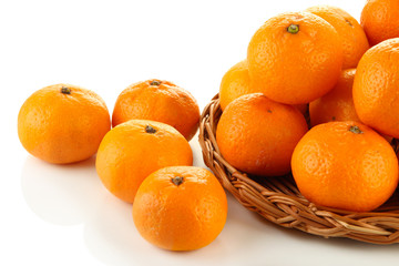 Ripe tangerines on wicker stand isolated on white