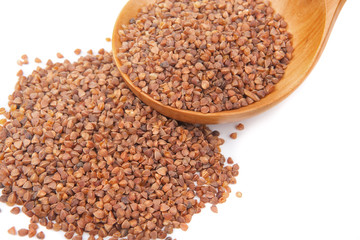 Buckwheat groats on a wooden spoon. Close-up.
