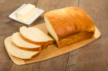 Loaf of sliced bread with butter plate