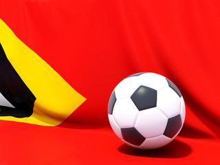 Naklejka premium Flag of east timor with football in front of it