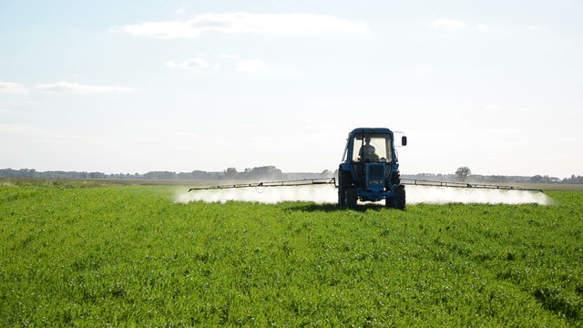 Tractor spray field with herbicide and insecticide chemicals