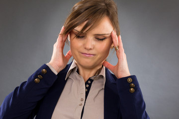 Closeup portrait of a young businesswoman with headache