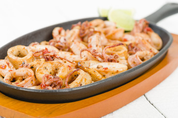 Fried Squid Rings - Squid rings with red pepper in a sizzle pan