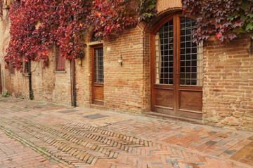picturesque street in small old tuscan town  in autumnal colors