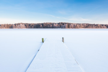 Fototapeta premium frozen snowy lake and a pier