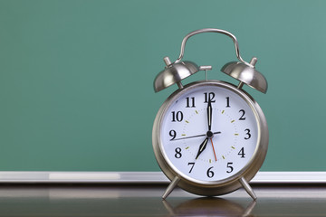 Alarm clock and green chalkboard