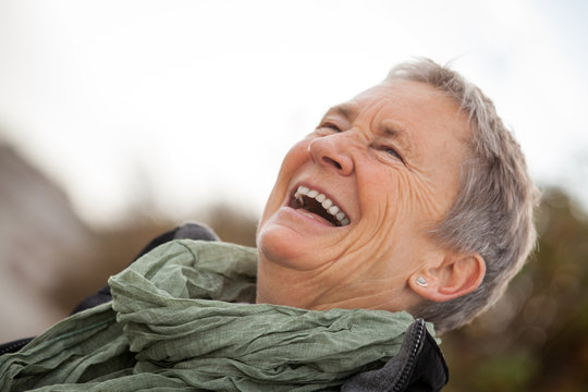 lachende glückliche ältere frau seniorin im herbst draussen