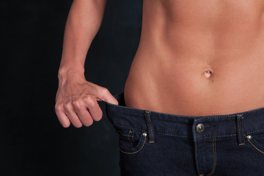 A fit attractive woman's stomach after a diet with jeans