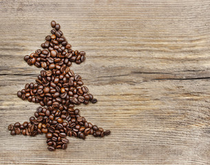 Shape of christmas tree made of coffee beans on wooden table