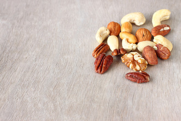 Assorted healthy mixed nuts on wooden textured background  