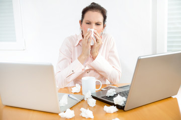 Beautiful young business woman with a cold blowing nose