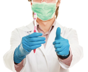 A male dentist with a toothbrush and showing ok ,