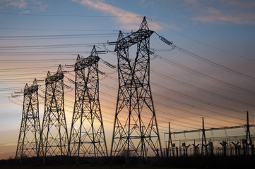 high voltage pylons silhouette cloudy sky background © ThomasLENNE