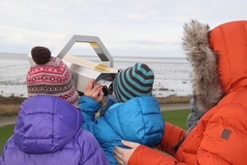 Mutter mit zwei Kindern am Fernglas