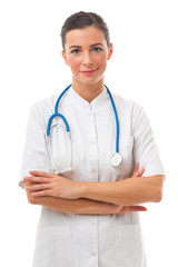 Fototapeta premium Young attractive woman doctor with stethoscope stands over white