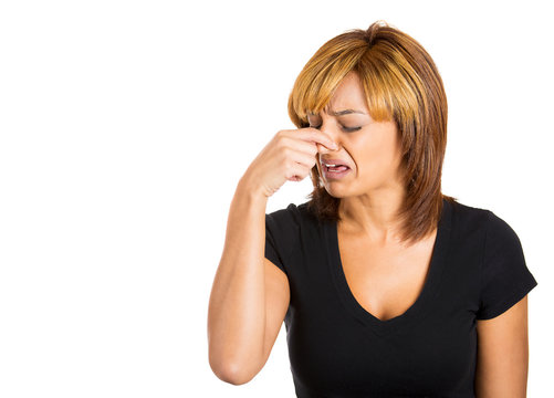 Woman pinches her nose, something stinks, very bad smell