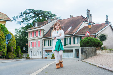 Cute little girl walking on a street in a village