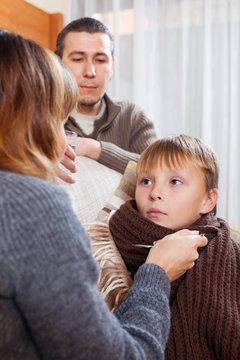 caring parents giving medicinal sirup to teenage boy