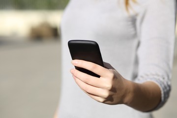 Woman hand holding and browsing a smart phone outdoor