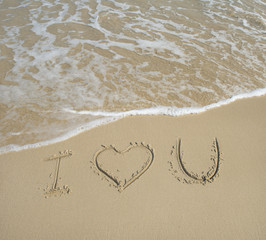 I love U on the sand texture background