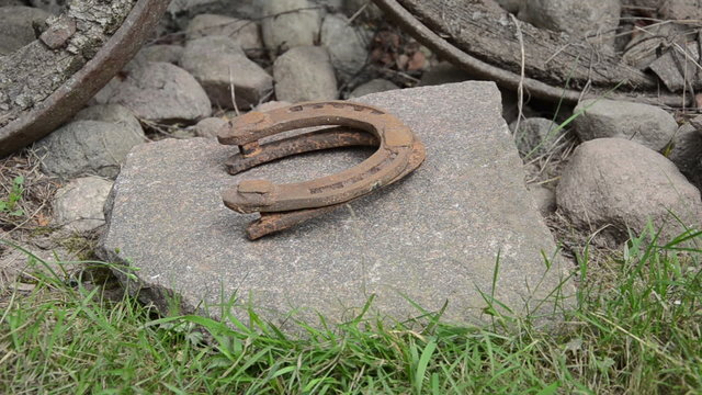 hand make stack of rusty retro horse shoes on stones background