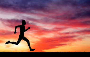 Silhouette of running man on sunset fiery background