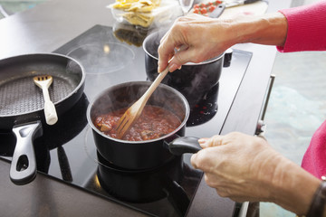 Cropped image of senior woman preparing food at kitchen counter