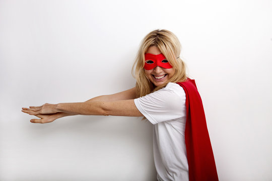 Side view portrait of happy woman in superhero costume against white background